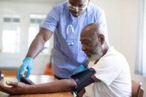 A healthcare provider checks a patient's blood pressure using a cuff during a routine exam.